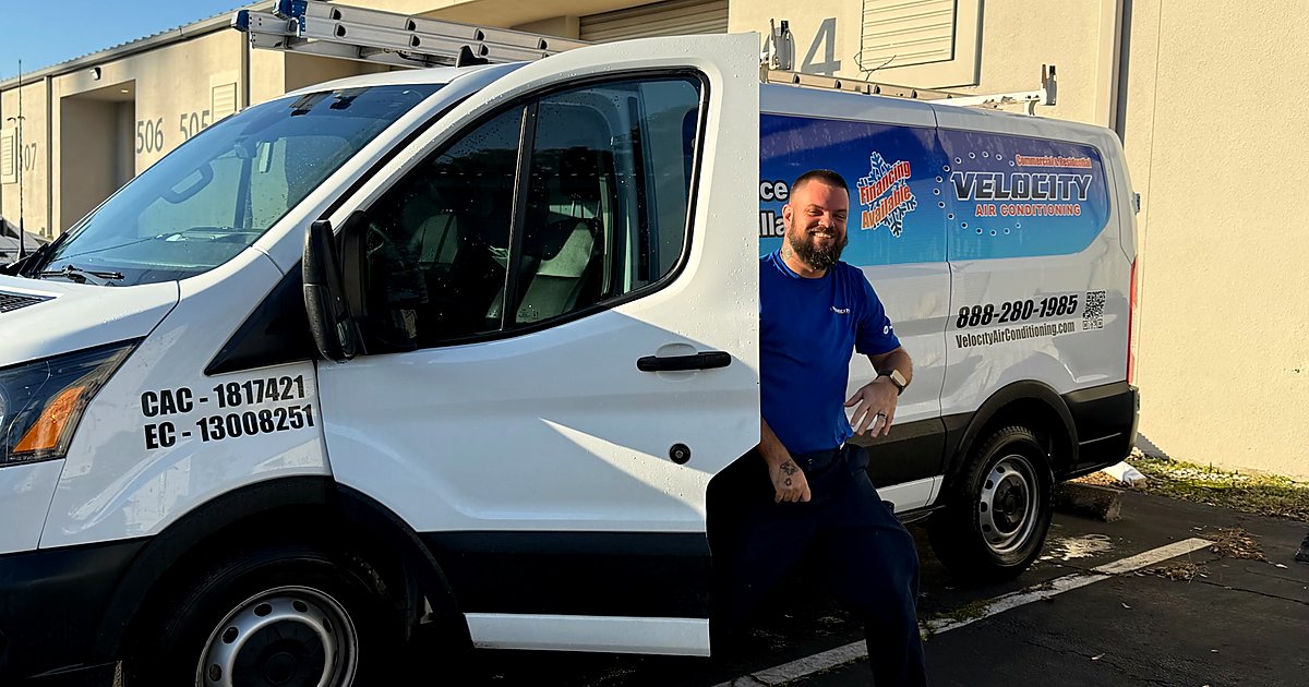 Velocity Air Conditioning technician inspecting a residential HVAC condenser in Hillsborough County